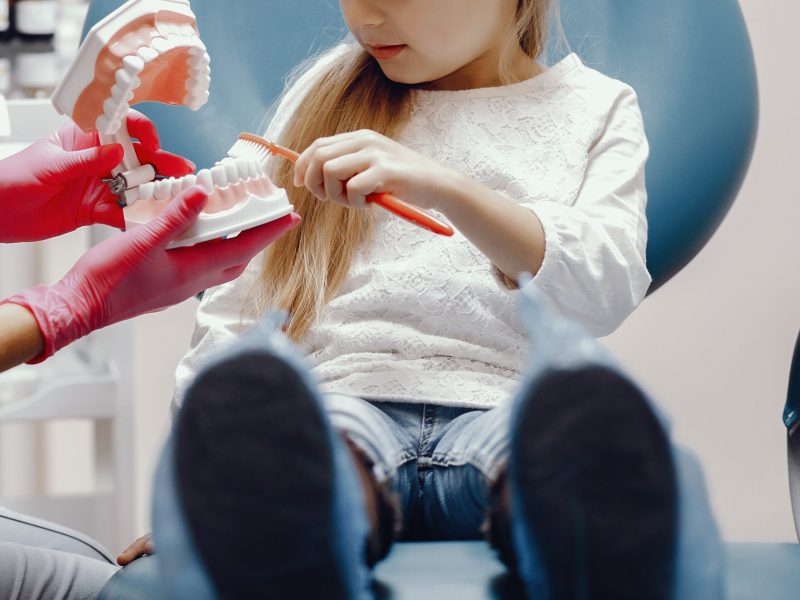 Cute little girl sitting in the dentist's office